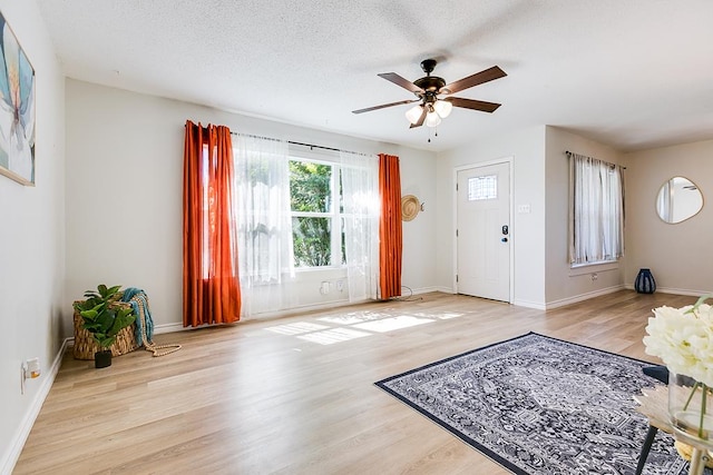 entrance foyer with a textured ceiling, light hardwood / wood-style floors, and ceiling fan