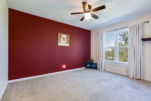 carpeted empty room with ceiling fan and a textured ceiling