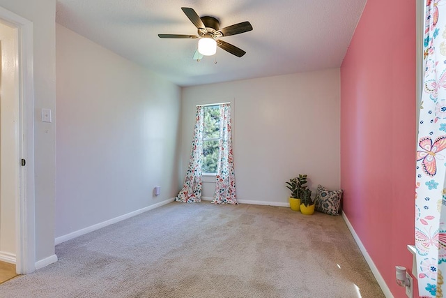 carpeted spare room with ceiling fan