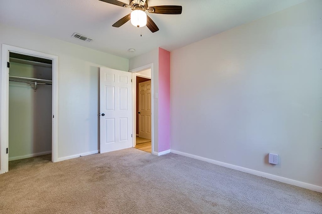 unfurnished bedroom with light carpet, a closet, and ceiling fan