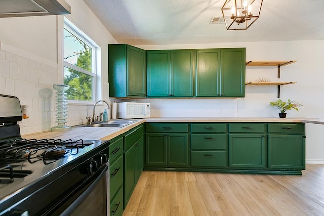 kitchen with extractor fan, sink, green cabinets, light hardwood / wood-style floors, and gas stove