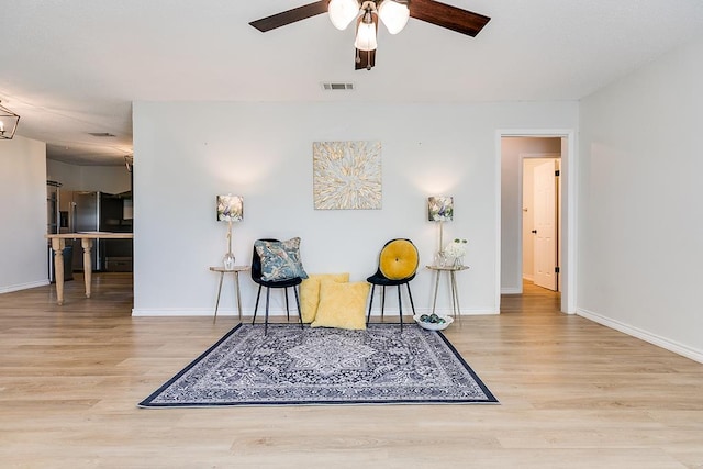 living area featuring wood-type flooring and ceiling fan