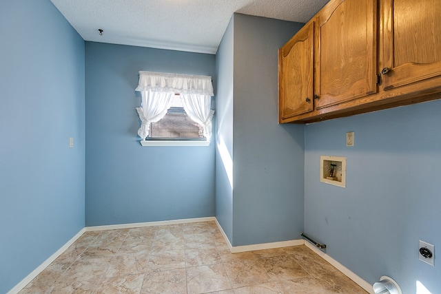 laundry area with cabinets, electric dryer hookup, washer hookup, and a textured ceiling