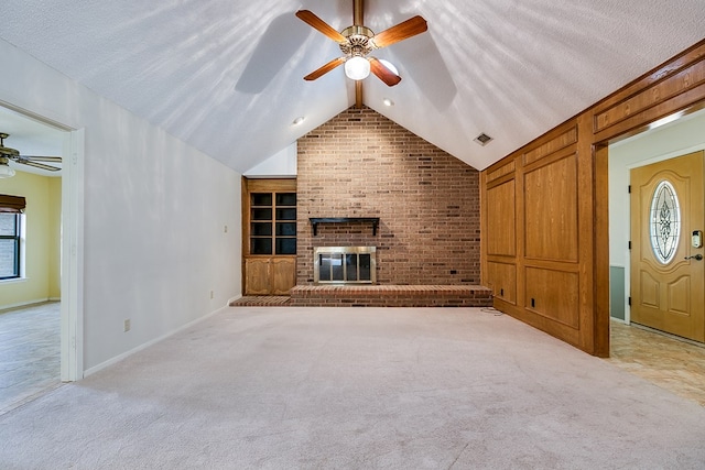 unfurnished living room with vaulted ceiling, light carpet, ceiling fan, and a fireplace