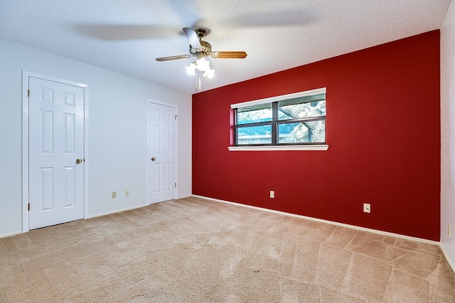 carpeted spare room with ceiling fan and a textured ceiling