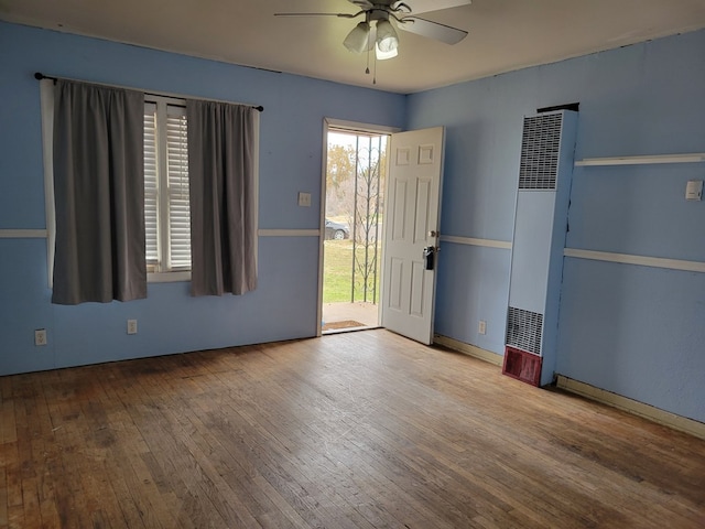 13 E 18th St, San Angelo, TX 76903 - unfurnished room featuring a heating unit, hardwood / wood-style floors, and a ceiling fan