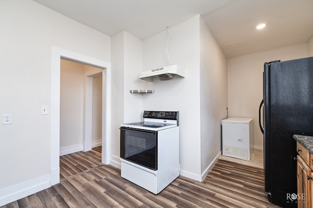 415 E Harris Ave, San Angelo, TX 79903 - kitchen featuring white range with electric cooktop, freestanding refrigerator, premium range hood, dark wood-style flooring, and recessed lighting