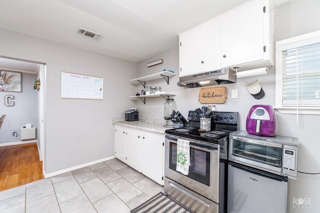 kitchen with light tile patterned flooring, stainless steel appliances, and white cabinets