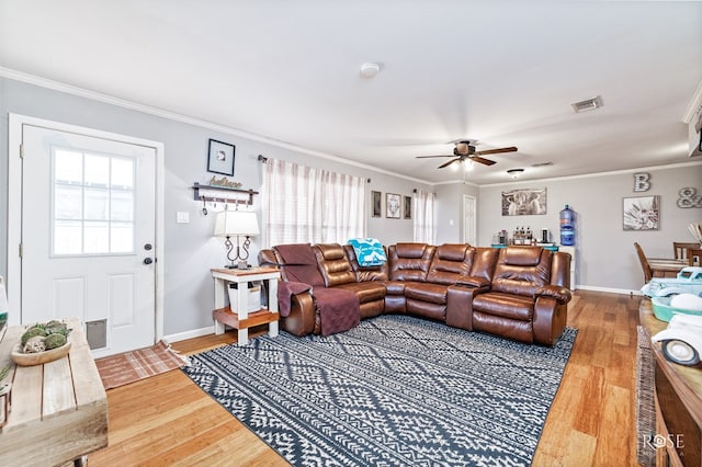 living room featuring hardwood / wood-style flooring, ceiling fan, and ornamental molding