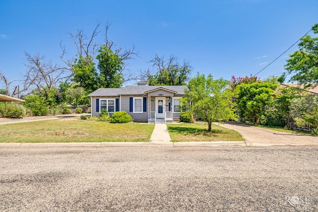 1951 W Twohig Ave, San Angelo, TX 76901 - view of front of house featuring a front yard, driveway, and a chimney