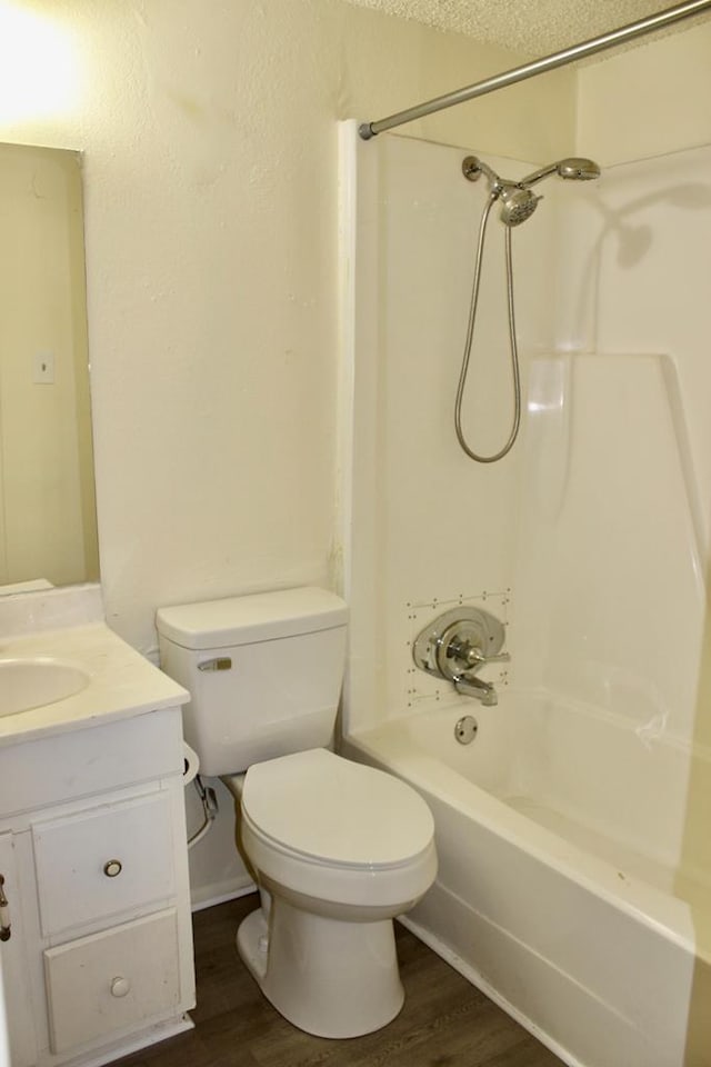 full bathroom with vanity, toilet, hardwood / wood-style floors, and  shower combination