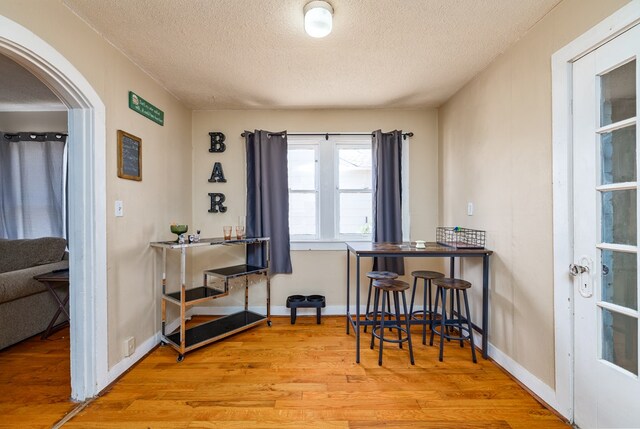 dining space featuring light hardwood / wood-style flooring and a textured ceiling