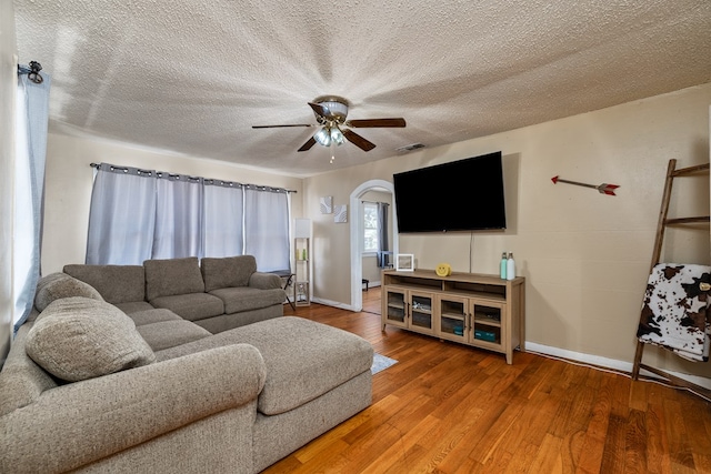 living room with ceiling fan, hardwood / wood-style floors, and a textured ceiling