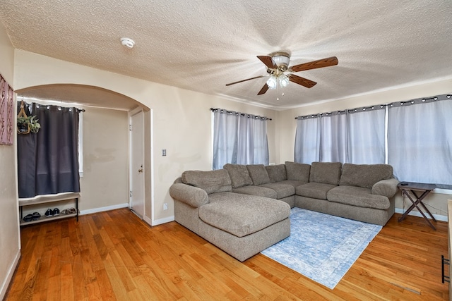 living room with ceiling fan, hardwood / wood-style flooring, and a textured ceiling