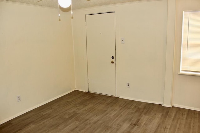 unfurnished room with ceiling fan, a textured ceiling, and dark hardwood / wood-style flooring