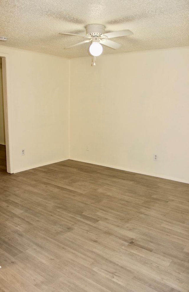 empty room with hardwood / wood-style flooring, ceiling fan, and a textured ceiling