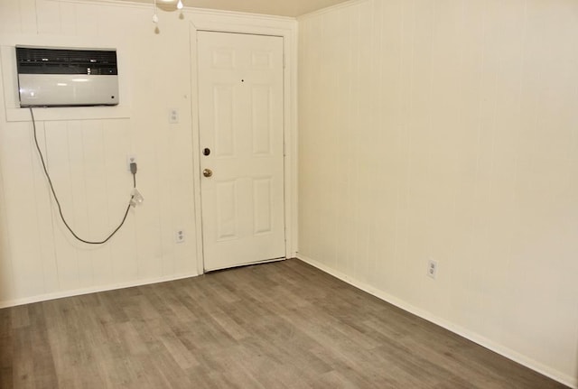 unfurnished room featuring a wall mounted AC and hardwood / wood-style floors