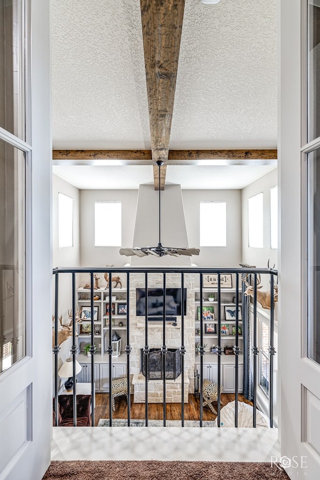 room details featuring a textured ceiling, beamed ceiling, and wood finished floors