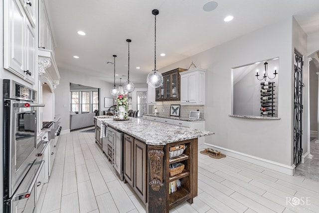 kitchen featuring glass insert cabinets, white cabinets, dark brown cabinetry, and a center island with sink