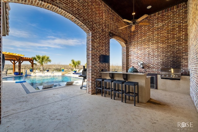 view of patio featuring outdoor wet bar, ceiling fan, area for grilling, and a pergola