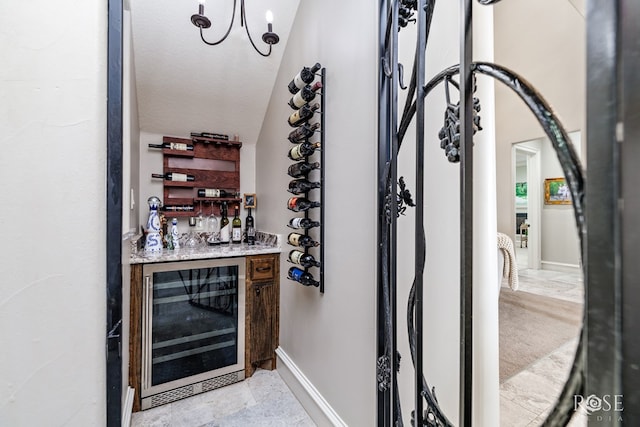 wine room featuring beverage cooler, a textured ceiling, and baseboards