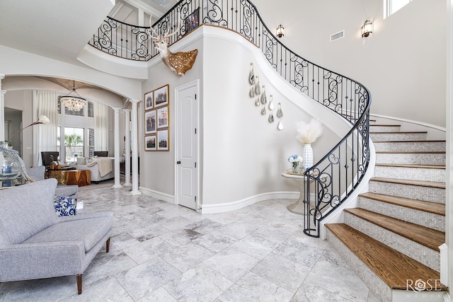 interior space with arched walkways, baseboards, visible vents, and ornate columns