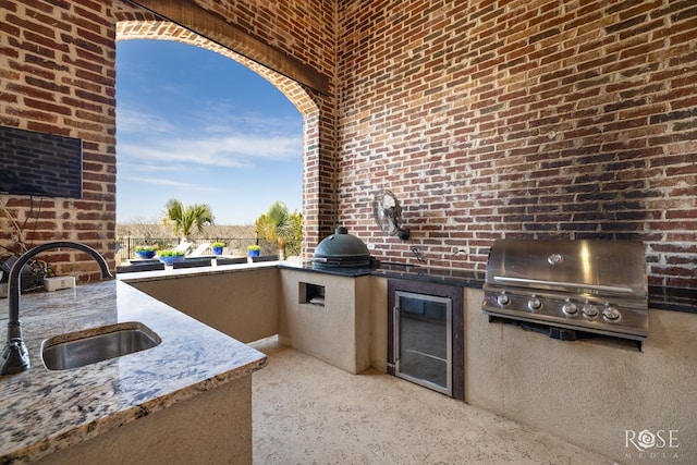 view of patio with exterior kitchen, a sink, grilling area, and fence