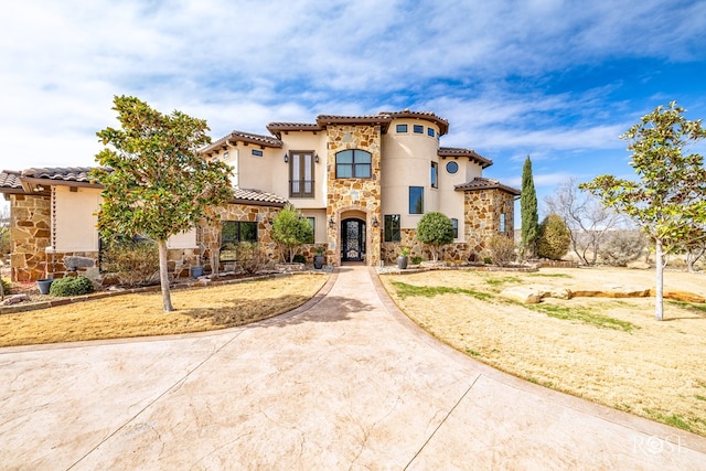 mediterranean / spanish-style home featuring stone siding, a tiled roof, and stucco siding