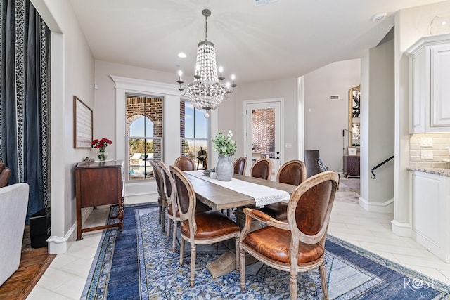 dining space featuring baseboards and an inviting chandelier