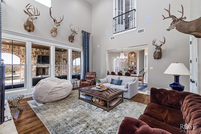 living area with a wealth of natural light, dark wood-style flooring, and visible vents