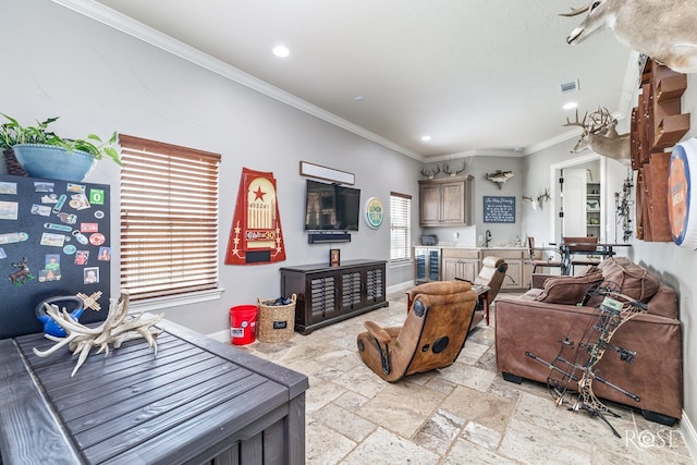 living room with wine cooler, baseboards, crown molding, and stone tile floors