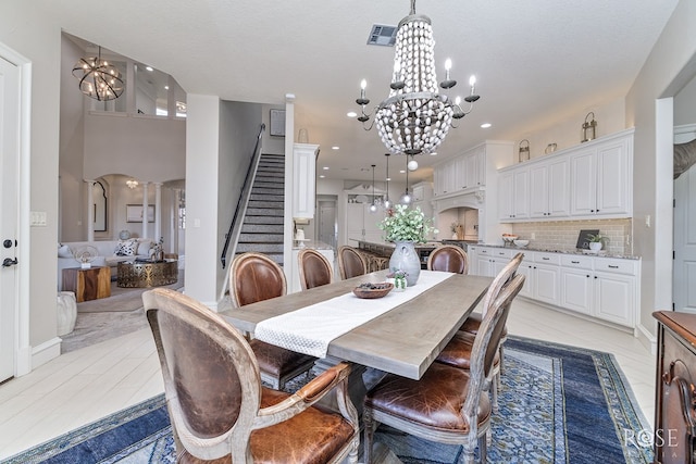 dining room with a textured ceiling, stairs, visible vents, and a notable chandelier