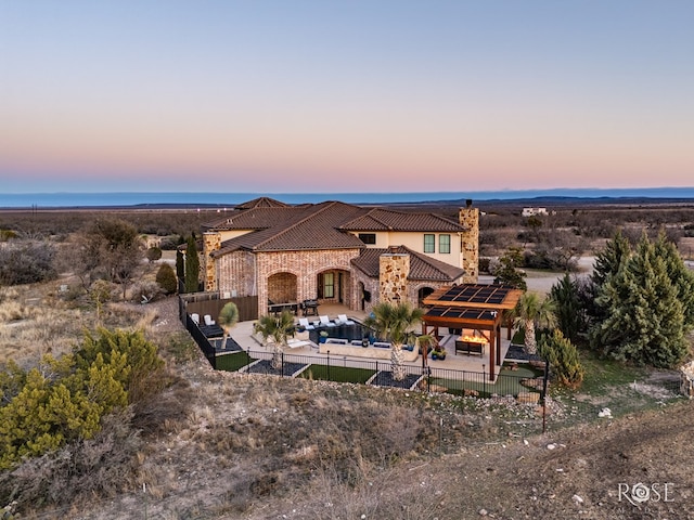 exterior space featuring fence private yard, a tiled roof, stone siding, and stucco siding