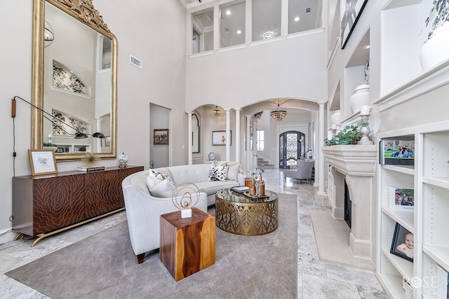 living room with ornate columns, visible vents, and arched walkways