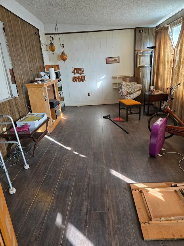 interior space with hardwood / wood-style floors, a textured ceiling, and wood walls