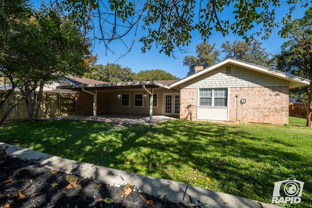 rear view of house with a yard and a patio