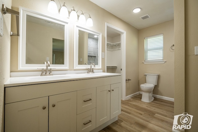 bathroom with hardwood / wood-style flooring, vanity, and toilet