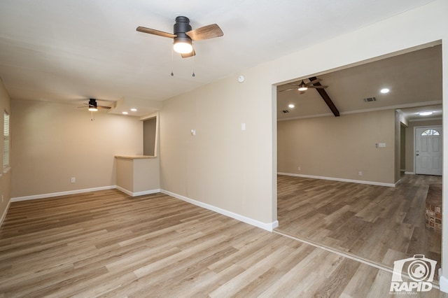 spare room featuring beamed ceiling, hardwood / wood-style floors, and ceiling fan