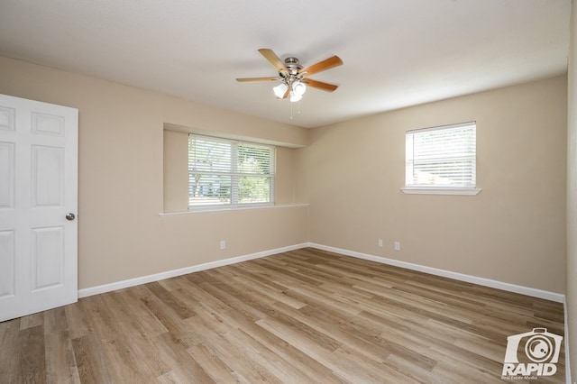 empty room with plenty of natural light, ceiling fan, and light wood-type flooring