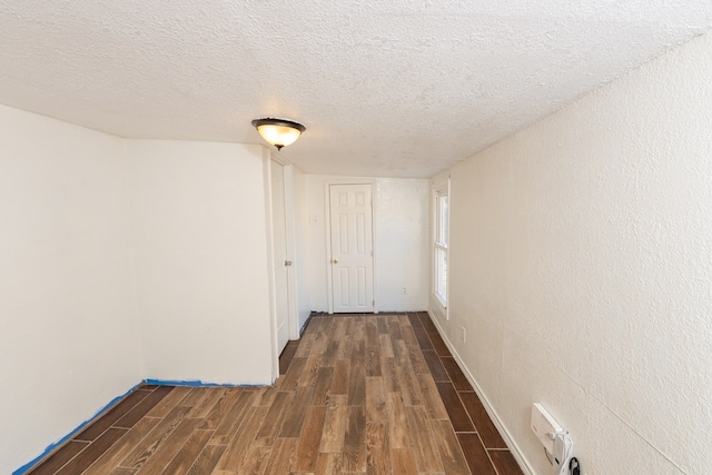 corridor with dark wood-type flooring and a textured ceiling