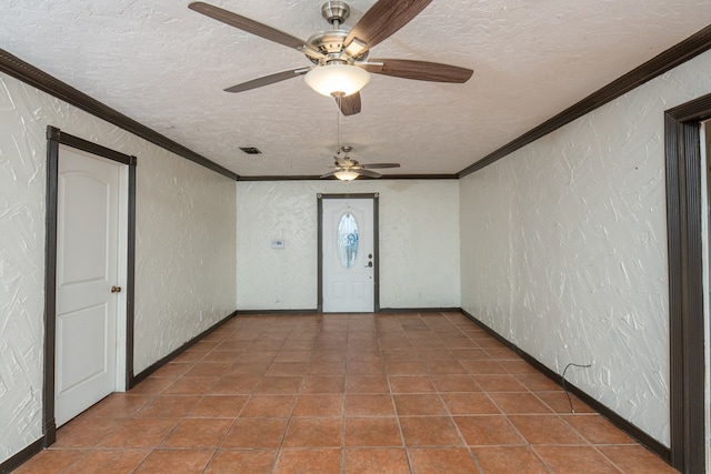 tiled foyer entrance with crown molding and a textured ceiling