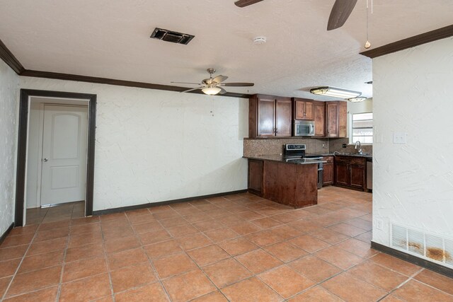 kitchen featuring sink, ceiling fan, appliances with stainless steel finishes, ornamental molding, and a textured ceiling