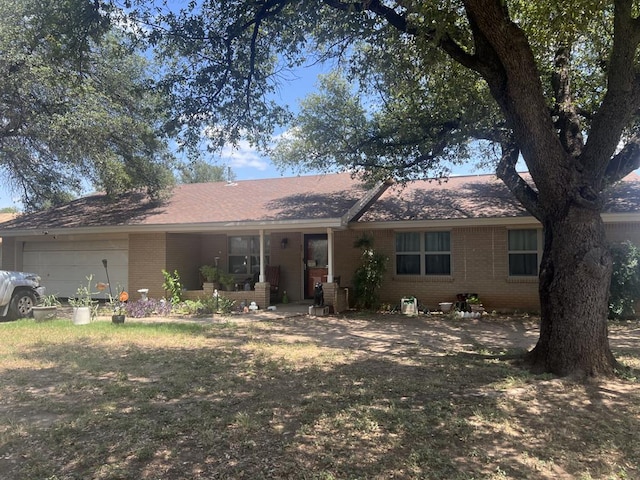 single story home with a garage, a porch, and a front yard