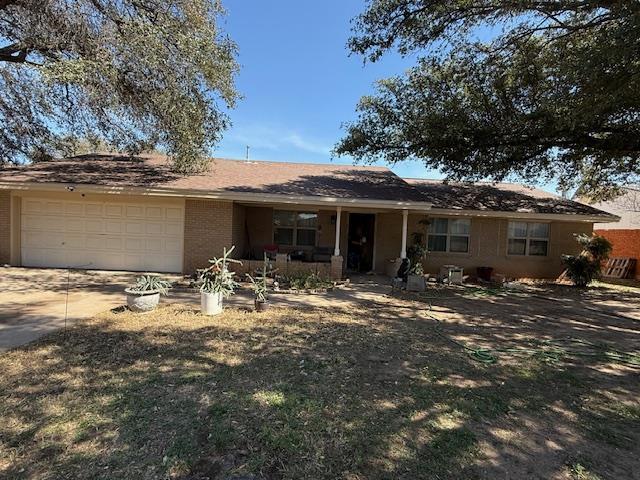 ranch-style house with a garage, driveway, and brick siding