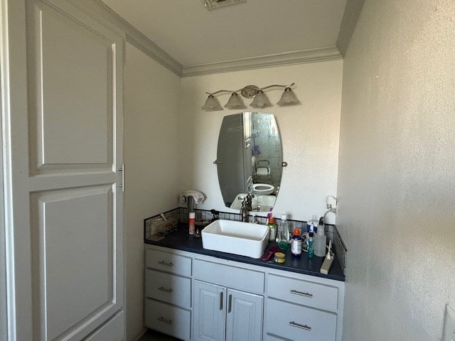 bathroom with visible vents, vanity, and crown molding