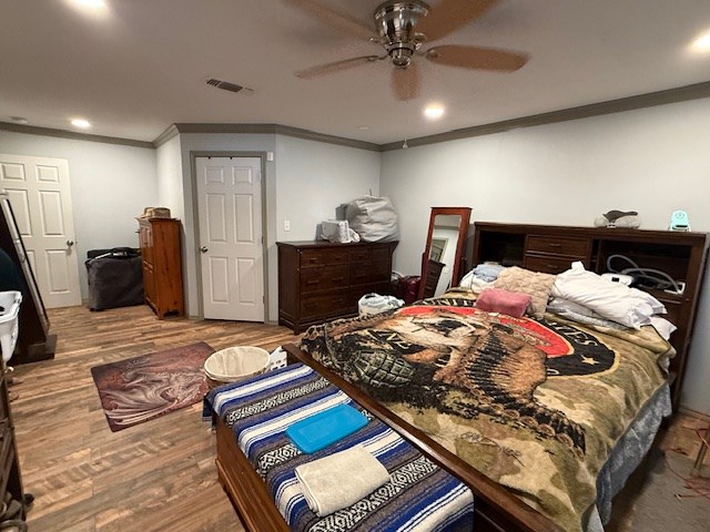 bedroom featuring visible vents, ceiling fan, wood finished floors, crown molding, and recessed lighting