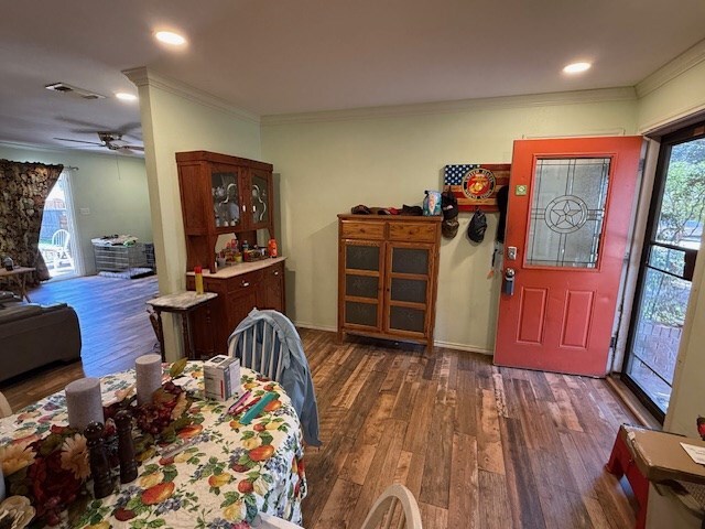 bedroom featuring crown molding, dark wood-type flooring, ceiling fan, and a closet