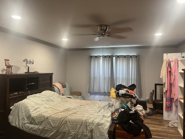 bedroom featuring crown molding, dark wood-type flooring, and ceiling fan