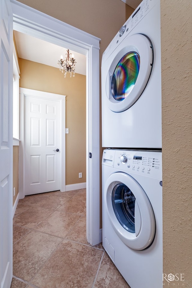 3045 Red Bluff Cir, San Angelo, TX 76904 - clothes washing area featuring stacked washing machine and dryer, a chandelier, and baseboards