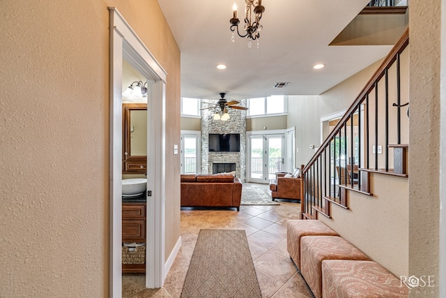 3045 Red Bluff Cir, San Angelo, TX 76904 - living room with ceiling fan, stairway, a stone fireplace, a textured wall, and recessed lighting